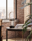 Modern interior with a brown armchair, round table, and cityscape view.