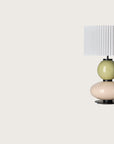 Modern table lamp with a yellow and white glass base and a pleated shade from Aromas. Available at Spacio retails stores in India.