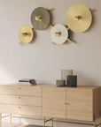 Modern wall-mounted light fixtures on a neutral wall with a wooden cabinet below.