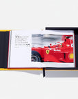 Open book showing a red Ferrari racing car with visible branding on a white background