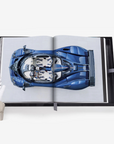Open book displaying a detailed illustration of a blue car on a white background