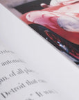 Close-up of a magazine or book with text and a car advertisement.
