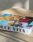 Elegant lifestyle image of Assouline Dolce Vita coffee table book on stone table, capturing Italian glamour and sophistication, available at Spacio India online.