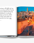 Inside pages of Assouline Dolce Vita book showcasing a beautiful Italian coastal town illuminated at night with a vintage quote, available at Spacio India.