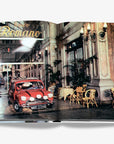 Vintage Italian car driving through an iconic historic arcade, featured in Assouline Dolce Vita luxury coffee table book, exclusively at Spacio India stores.