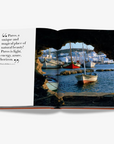 Artistic photograph of boats at Paros harbour paired with a captivating quote in Assouline's Greek Islands luxury book, available at Spacio India.