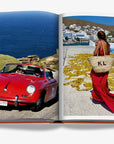 Open pages from Assouline's Greek Islands Coffee Table Book showing scenic drives and vibrant island life, available at Spacio India.