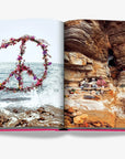 Striking peace sign floral arrangement and cliffside meditation scene featured in Ibiza Bohemia by Assouline, luxury travel book at Spacio India.