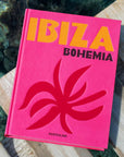 Assouline Ibiza Bohemia coffee table book placed on a dock above clear water, representing luxury travel and island lifestyle, available at Spacio India online.