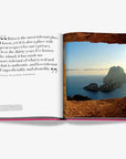 Assouline Ibiza Bohemia book page featuring inspiring quote and breathtaking view of Es Vedrà island through a rock frame, offered at Spacio India.