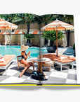 A luxurious Miami poolside retreat with sunbeds, cabanas, and lush tropical greenery, perfect for an indulgent getaway. From the Assouline Coffee Table Book Miami Beach, available at Spacio India.