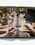 A detailed photograph from Assouline’s Coffee Table Book showing an expert watchmaker assembling fine luxury watches, reflecting craftsmanship and precision horology.