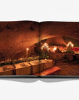 A dining table on a double spread in a luxurious Assouline Wine & Travel France coffee table book featuring France’s finest vineyards and wine regions, available at Spacio India retail stores and online.