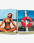 Miami Beach Lifestyle Photography Spread – A woman enjoying the sun on a beach and a classic red lifebuoy, featured in Assouline’s Miami Beach book. Shop this collectible edition at Spacio India.