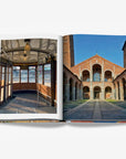 A vintage tram interior with wooden panels and curved glass windows and the historic Basilica di Sant'Ambrogio in Milan with its Romanesque architecture on a double spread in a luxurious Assouline Milan Chic coffee table book, showcasing Milan’s timeless elegance, now available at Spacio India’s online store and retail outlets.