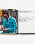 Double spread of a stylish man in a turquoise suit taking notes while holding a phone and a blue leather bag, with a quote about Milan’s elegance and creativity in a luxurious Assouline Milan Chic coffee table book, showcasing Milan’s timeless elegance, now available at Spacio India’s online store and retail outlets.