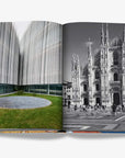A double spread of a contrasting architectural featuring a modern building with a sleek, blurred facade on the left and a black-and-white photograph of Milan's iconic Duomo cathedral on the right in a luxurious Assouline Milan Chic coffee table book, showcasing Milan’s timeless elegance, now available at Spacio India’s online store and retail outlets.
