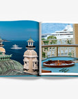 Stunning views of Monaco’s historic architecture, luxury yachts, and a classic casino roulette table on a double spread page of a luxurious Assouline's Monte Carlo coffee table book, featuring a vibrant cover with images of Monaco's iconic landmarks, available at Spacio India.