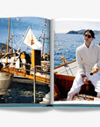 Double spread page of a classic vintage yacht scene and a stylish man in white enjoying a sailing experience on a wooden boat in luxurious Assouline's Monte Carlo coffee table book, featuring a vibrant cover with images of Monaco's iconic landmarks, available at Spacio India.