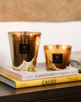 Set of Baobab Aurum Candles glowing on art books - jasmine and musk scented candles at Spacio India