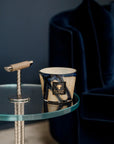 Baobab Stones Lazuli Candle Max 10 placed on a glass side table in a modern living room, showcasing its elegant marbled glass design. Available at Spacio India.