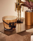 Baobab Stones Lazuli Candle Max 10 styled on a luxury console with flowers and gold accents, highlighting its artistic glass finish and musky sea salt scent. Available at Spacio India.