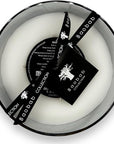 Top flat lay showing the three-wick Baobab Stones Marble Candle Max 10 with black ribbon and luxury tag from Spacio