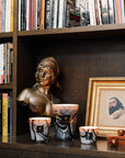 Trio of Baobab Stones Marble Candles Max 24 styled in a home library setting artisanal marbled glass design with masculine and feminine fragrance blend, available at Spacio India.