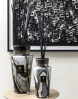Baobab Stones Marble Diffuser Totem 2L in black, grey, and white marble-patterned glass, styled against an artistic black-and-white backdrop, creating a luxurious interior setting, available at Spacio India retail stores and online.