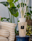 Baobab White Pearl Diffuser placed beside a comfortable sofa, enhancing interiors with its soft musk and freesia scent; elegant glass diffuser available at Spacio India.