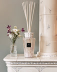 Luxurious Baobab White Pearl Diffuser on a classic white mantelpiece, complementing interiors with feminine notes of musk and freesia; shop now at Spacio India.