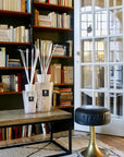 Baobab White Pearl Diffusers elegantly placed on a modern coffee table amidst a sophisticated home library, showcasing feminine fragrance, exclusively available at Spacio India.