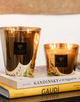 Set of Baobab Aurum Candles glowing on art books - jasmine and musk scented candles at Spacio India