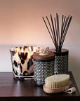 Luxurious Baobab Black Pearls Candle Max 10 lit beside elegant Esteban diffuser and spa brush, creating a calming ambience. Shop now at Spacio India.