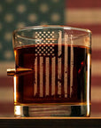 Glass with American flag design filled with a dark liquid, American flag in the background