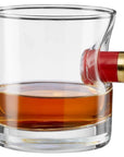 Glass filled with whiskey in a glass with shotgun shell casing, on a white background