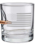 Clear whiskey glass with American flag engraving and a bullet casing on a white background from the American brand Benshot available at Spacio retail stores in Mumbai & Kolkata.