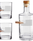 Clear whiskey glass decanter and two glasses with bullet on a white background from the American brand Benshot available at Spacio retail stores in Mumbai & Kolkata.