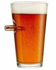 Pint glass filled with beer on a white background in a glass with bullet