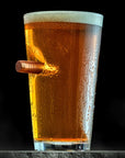 Pint Glass of beer with a bullet on a black background