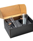 Two clear beer pint glass tumblers with bullets in a black box with a brown lid.
