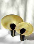 Two decorative vases with gold and black design on a light background