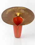Decorative vase with gold rim and red body on a white background