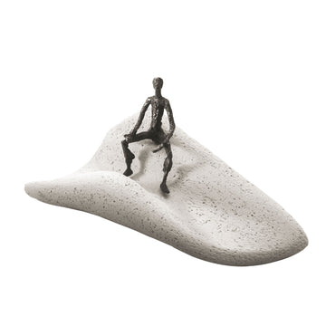 A captivating Butzon & Bercker Sculpture Intuition of a man sitting on a sand dune, crafted by Butzon Bercker.