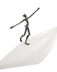 A Butzon Bercker sculpture representing new horizons, with a figure standing on top of a white surfboard.