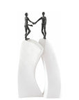 Two Butzon & Bercker Sculpture Shake Hands figurines on top of a white pedestal, symbolizing unity.