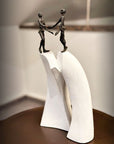 A Butzon Bercker sculpture of two people holding hands in a unified gesture.