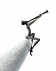 A high-quality Butzon Bercker sculpture of a man playing a trumpet on top of a pencil, entitled "Butzon & Bercker Sculpture Zest For Life II".