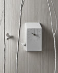 A Haoshi cuckoo clock on a wall next to a tree.