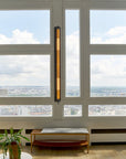 In the tube wall light from DCW Editions on a wall with windows showing city view